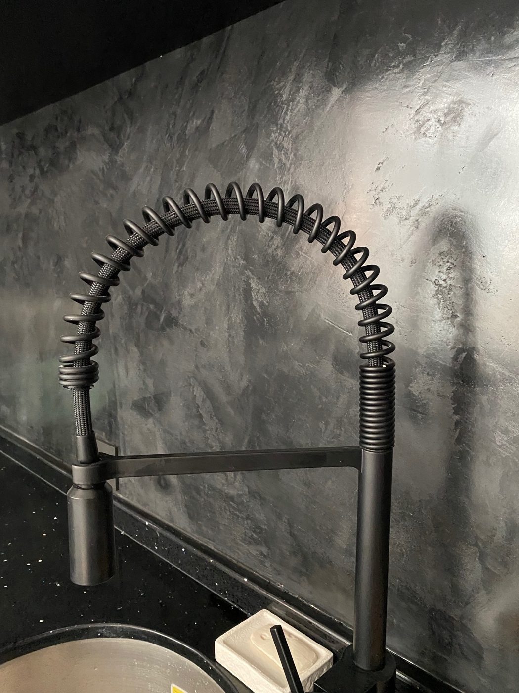 Backsplash y muro de microcemento negro en cocina